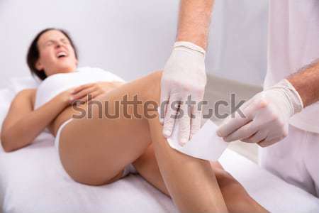 Beautician Using Laser Machine On Young Customer's Leg Stock photo © AndreyPopov