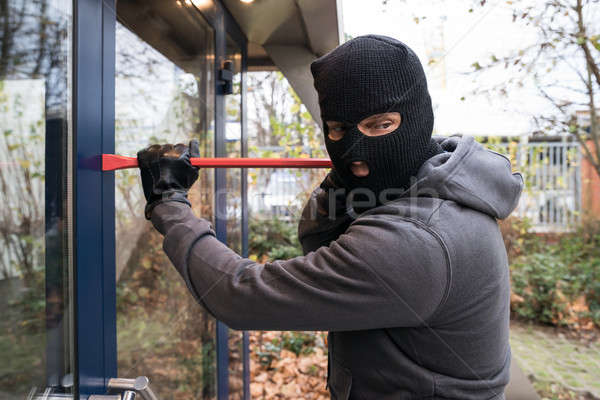 Man Using Crowbar To Open Glass Door Stock photo © AndreyPopov