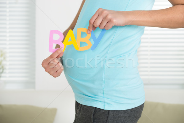 Stock photo: Pregnant Woman Holding Word Baby