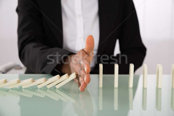 Businesswoman Stopping Dominoes From Falling Stock photo © AndreyPopov