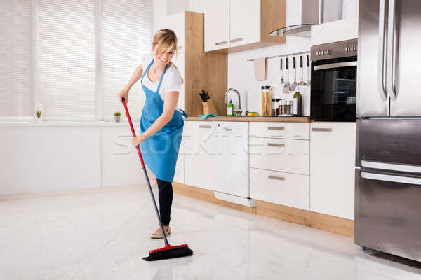 Housemaid Sweeping Floor In Kitchen Stock photo © AndreyPopov