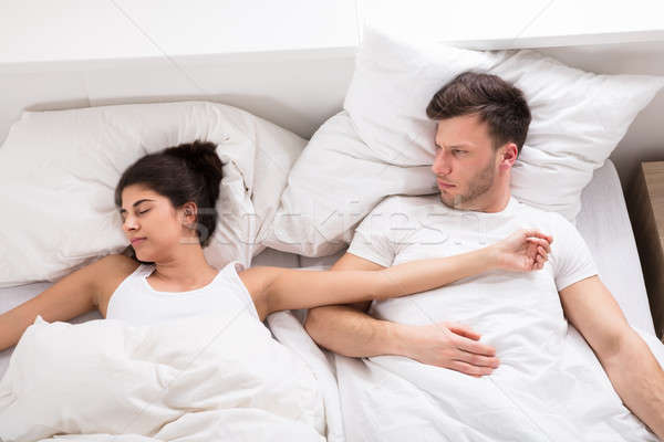 Man Looking At Her Wife Sleeping On Bed Stock photo © AndreyPopov