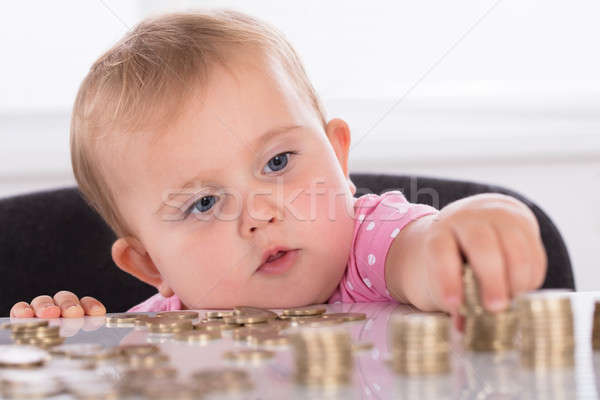 Baby Stacking Coins On Desk Stock photo © AndreyPopov