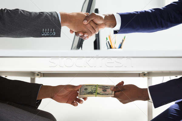 Two Businesspeople Shaking Hand And Taking Bribe Stock photo © AndreyPopov