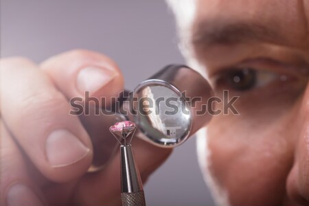 Jeweler Examining Diamond Through Loupe Stock photo © AndreyPopov