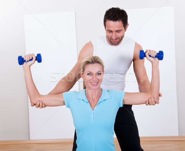 Fitness instructor helping a woman workout Stock photo © AndreyPopov