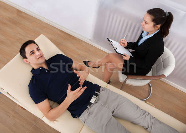 Stock photo: Male Patient Communicating While Psychologist Writing Notes
