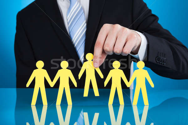 Businessman Holding Paper People Representing Recruitment Stock photo © AndreyPopov