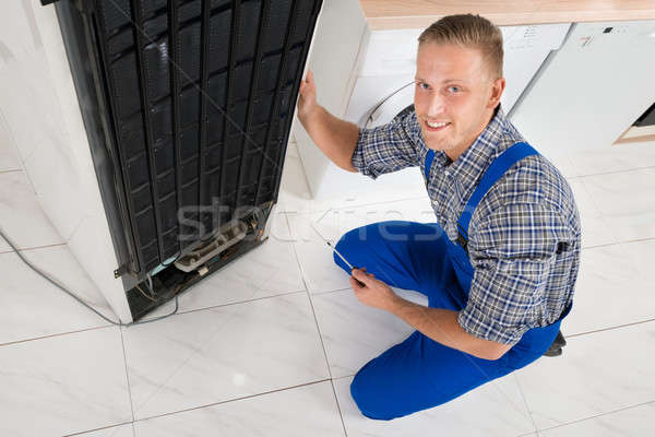 Stock photo: Repairman Repairing Fridge