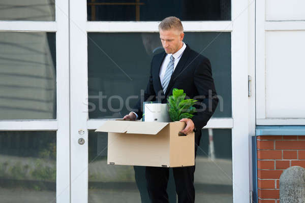 Businessman Carrying His Belongings In Box After Being Fired Stock photo © AndreyPopov