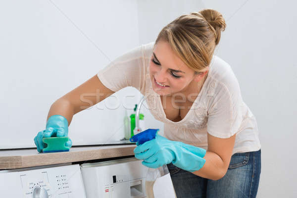 Kobieta czyszczenia blacie kuchennym gąbki młoda kobieta domu Zdjęcia stock © AndreyPopov