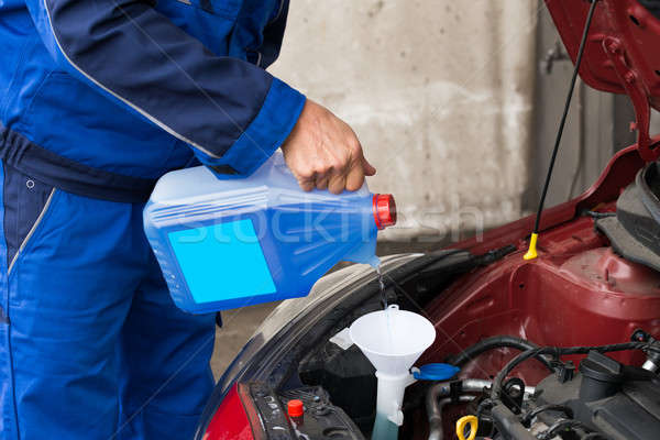 Serviceman Pouring Windshield Washer Fluid Into Car Stock photo © AndreyPopov