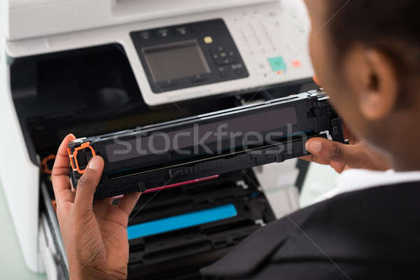 Businesswoman Fixing Cartridge In Office Stock photo © AndreyPopov