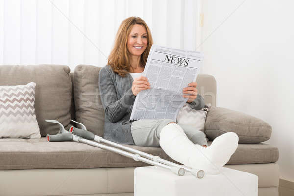 Mujer pierna lectura periódico mujer madura casa Foto stock © AndreyPopov