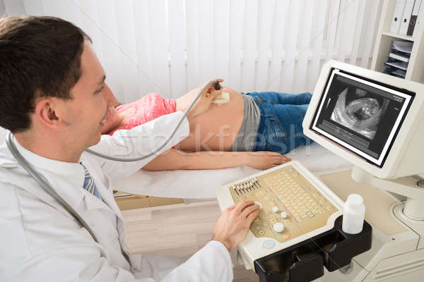 Doctor Moving Ultrasound Transducer On Pregnant Woman's Belly Stock photo © AndreyPopov