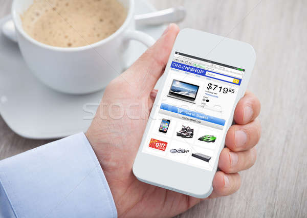 Person Hand Shopping Online While Holding Mobilephone Stock photo © AndreyPopov