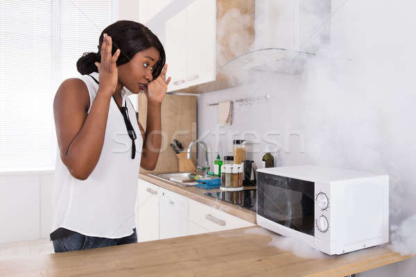 Donna guardando pizza forno a microonde forno scioccato Foto d'archivio © AndreyPopov