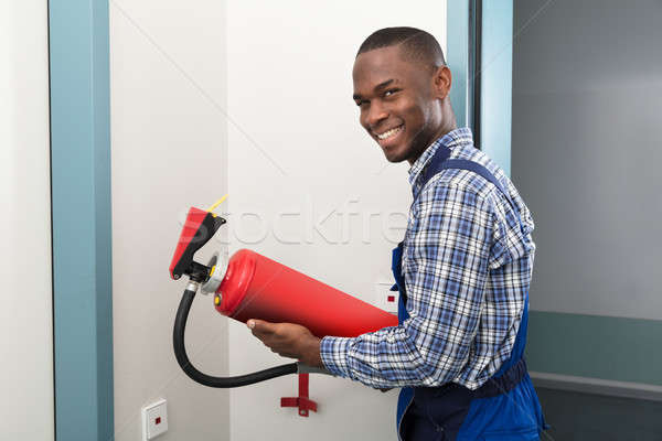 Male African Professional Holding Fire Extinguisher Stock photo © AndreyPopov