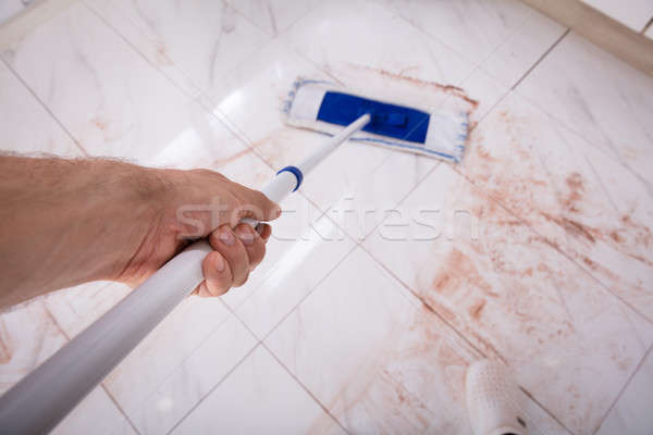 Stock photo: Person Holding Mop And Mopping Dirty Kitchen Floor
