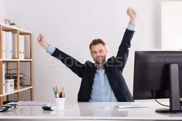 Happy Young Businessman Sitting In Office Stock photo © AndreyPopov