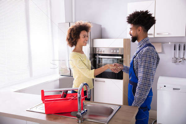 Serrer la main jeune femme uniforme cuisine maison [[stock_photo]] © AndreyPopov