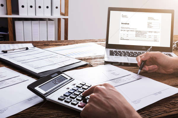 Businessperson's Hand Calculating Bill With Calculator Stock photo © AndreyPopov