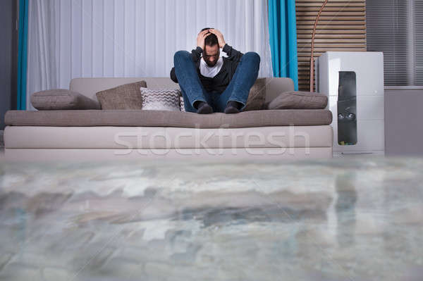 Zaklatott férfi szoba víz kanapé kezek Stock fotó © AndreyPopov