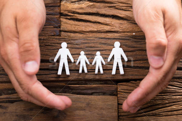 Elevated view of businessperson protecting family figures Stock photo © AndreyPopov