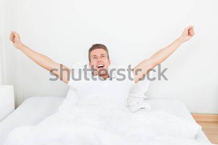 Stock photo: Man Waking Up In Morning And Stretching On Bed