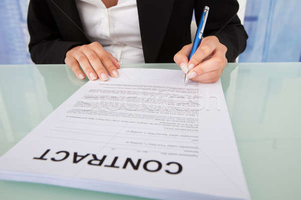 Geschäftsfrau Unterzeichnung Vertrag Papier Schreibtisch jungen Stock foto © AndreyPopov