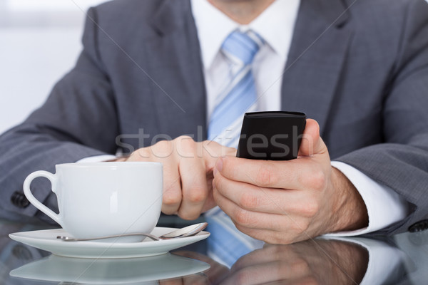 Empresario teléfono celular taza de café escritorio primer plano Internet Foto stock © AndreyPopov