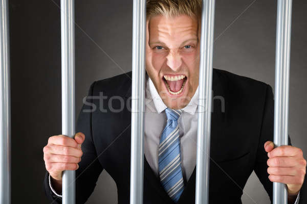 Aggressive Businessman Behind Bars Stock photo © AndreyPopov