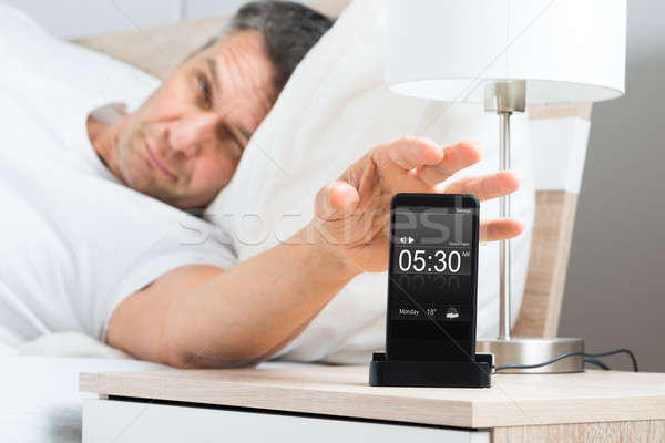 Man On Bed With Cell Phone Stock photo © AndreyPopov