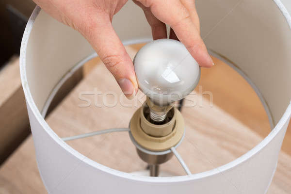 Woman Fixing Lamp At Home Stock photo © AndreyPopov