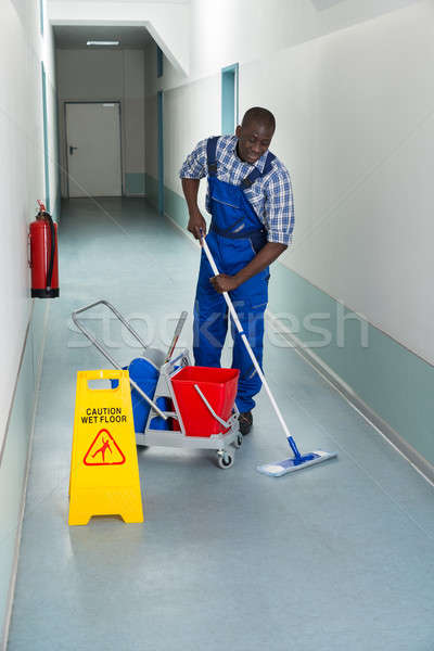 Stock photo: Male Janitor Cleaning Floor