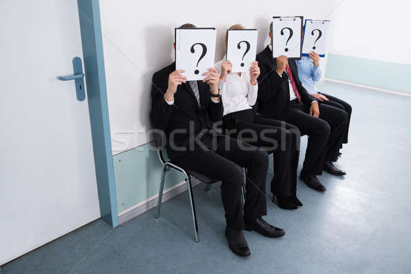 Geschäftsleute versteckt hinter Fragezeichen Zeichen Sitzung Stock foto © AndreyPopov