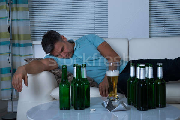 Borracho hombre toma siesta sofá cerveza Foto stock © AndreyPopov