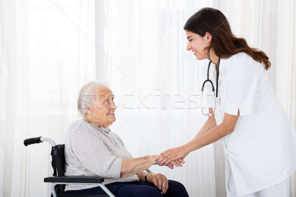 Female Doctor Consoling Disabled Senior Patient Stock photo © AndreyPopov
