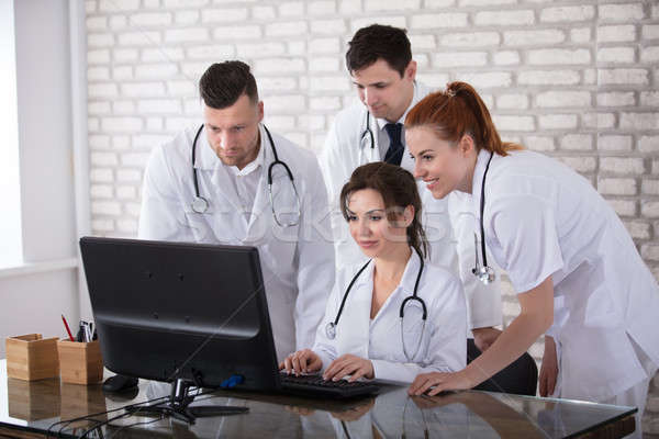 Gruppo medici guardando computer sorridere clinica Foto d'archivio © AndreyPopov