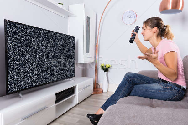 Woman Frustrated With A TV Screen Glitch Stock photo © AndreyPopov