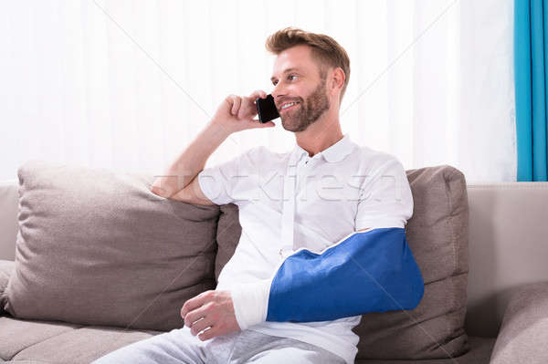 Man With Fractured Hand Talking On Mobile Phone Stock photo © AndreyPopov
