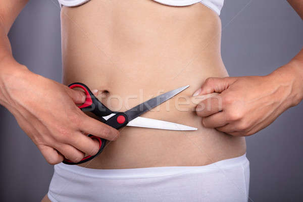 Woman Cutting Belly Fat With Scissors Stock photo © AndreyPopov