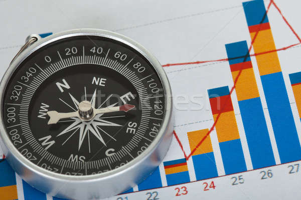 Compass on top of business data papers Stock photo © AndreyPopov