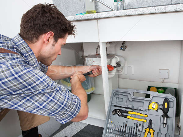 Plumber Fixing Sink In Kitchen Stock photo © AndreyPopov