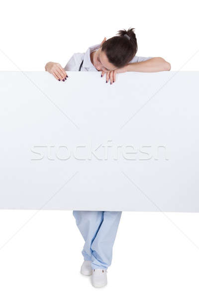 Doctor or nurse with blank signboard Stock photo © AndreyPopov