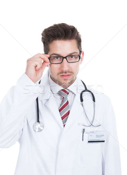 Confident Young Male Doctor Adjusting Glasses Stock photo © AndreyPopov