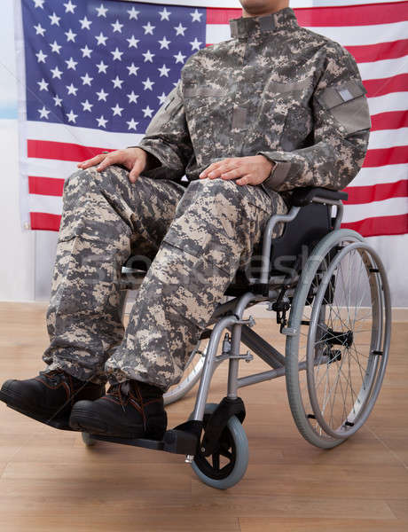 Patriotic Soldier Sitting On Wheel Chair Against American Flag Stock photo © AndreyPopov