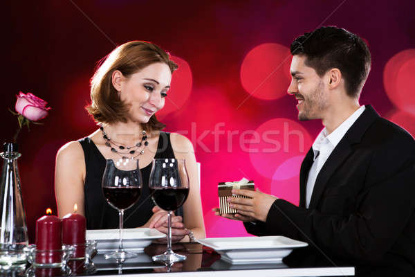 Stock photo: Loving Man Giving Present To Woman At Restaurant