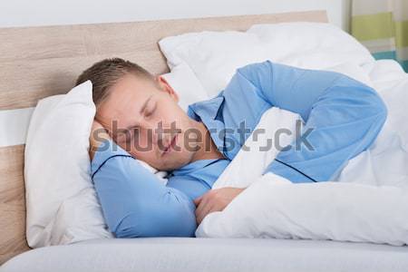 Depressed Man On Bed While Woman Sleeping Stock photo © AndreyPopov
