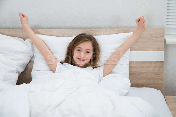Fată in sus pat zâmbitor zâmbet copil Imagine de stoc © AndreyPopov
